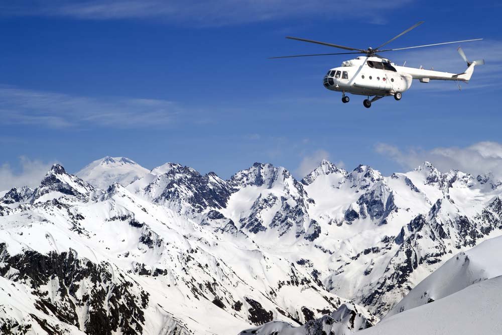 Helicopter Flying Above a Snowy Mountain